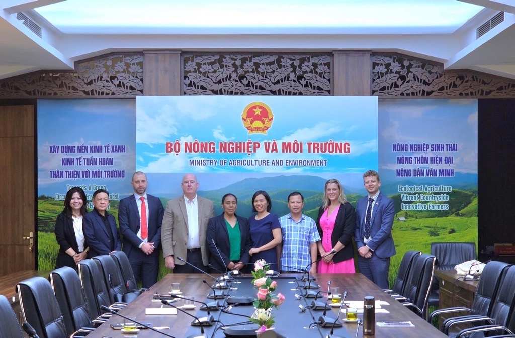 Group of people stood at the end of a board room table.